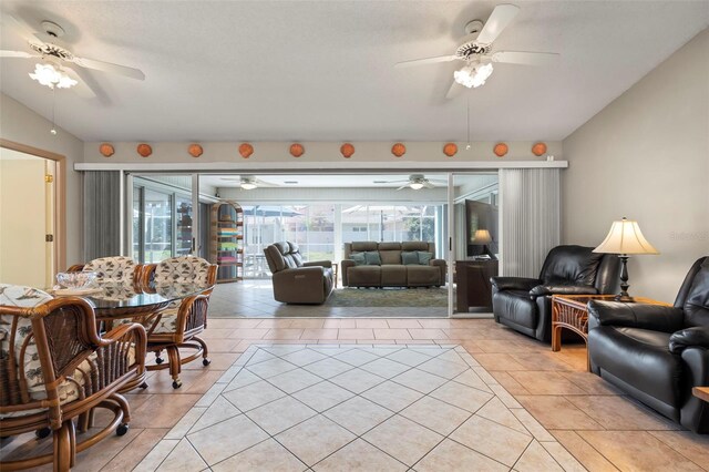 living room featuring vaulted ceiling, ceiling fan, and light tile patterned flooring