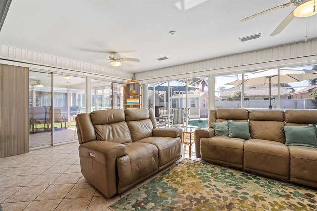 living room with light tile patterned floors, a sunroom, visible vents, and a ceiling fan