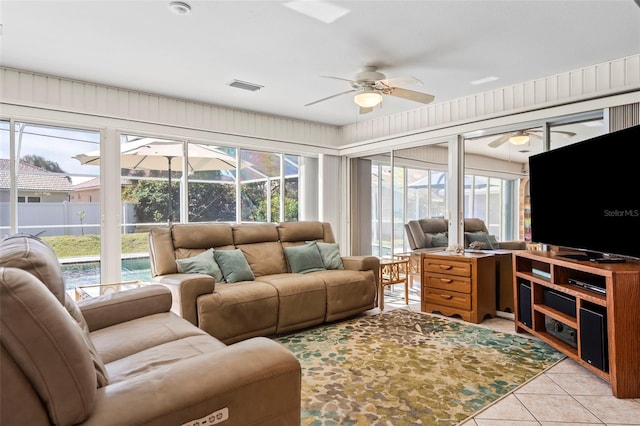 living area featuring a ceiling fan, a sunroom, visible vents, and light tile patterned flooring