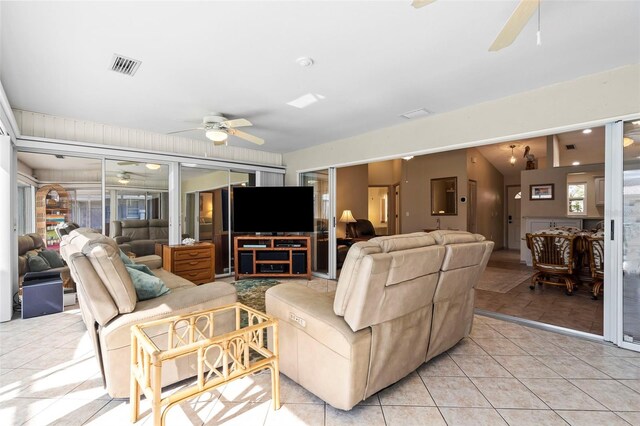 living area featuring a ceiling fan, visible vents, and light tile patterned floors