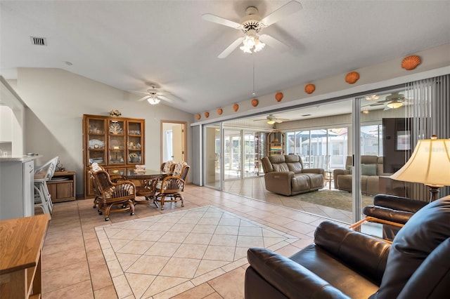 living area with light tile patterned floors, ceiling fan, vaulted ceiling, and visible vents