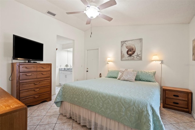 bedroom with lofted ceiling, light tile patterned flooring, connected bathroom, and visible vents