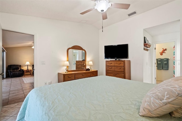 tiled bedroom with lofted ceiling, visible vents, and a ceiling fan