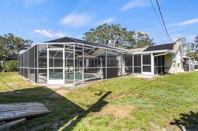 rear view of property featuring an outdoor pool, a yard, and a lanai