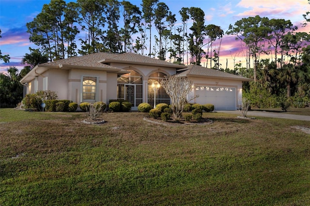 view of front facade featuring a garage and a lawn