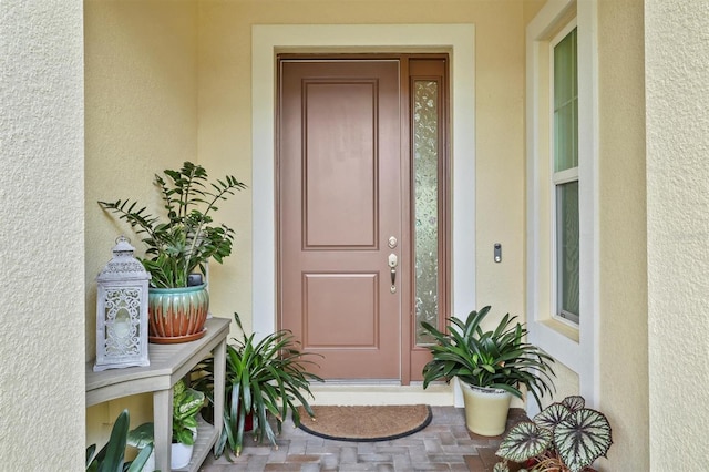 view of exterior entry featuring stucco siding