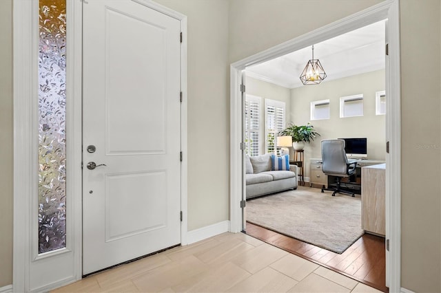 foyer entrance featuring baseboards, an inviting chandelier, and light wood-style floors