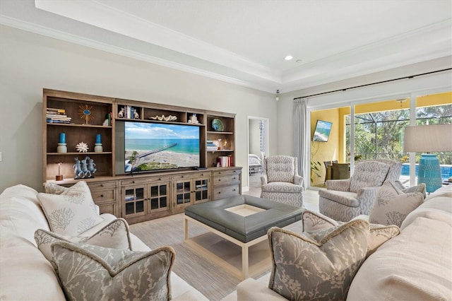 living room featuring a sunroom, recessed lighting, a raised ceiling, and crown molding