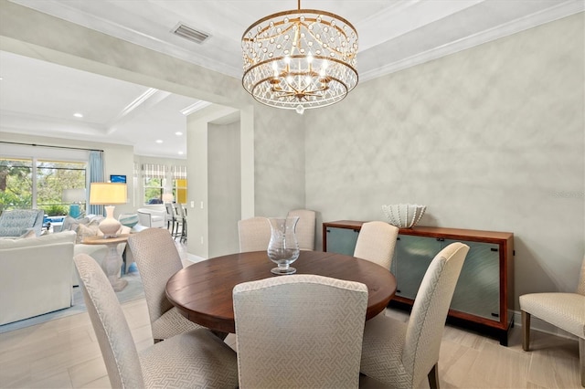 dining room featuring visible vents, a raised ceiling, ornamental molding, an inviting chandelier, and recessed lighting