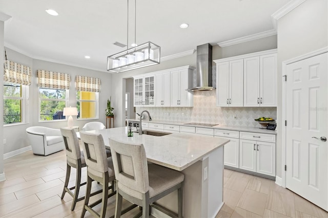 kitchen with backsplash, a sink, wall chimney range hood, and black electric stovetop