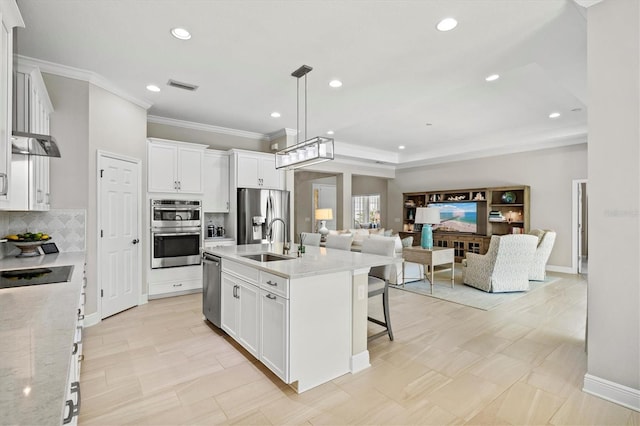 kitchen with stainless steel appliances, tasteful backsplash, visible vents, open floor plan, and a sink