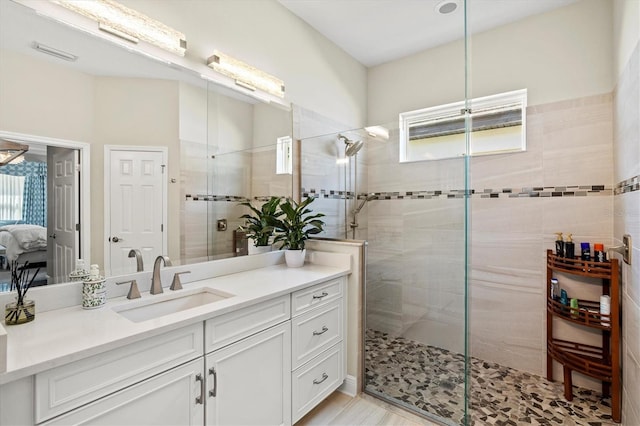 ensuite bathroom with visible vents, ensuite bath, a shower stall, and vanity