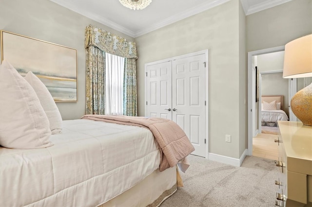 carpeted bedroom with a closet, crown molding, and baseboards