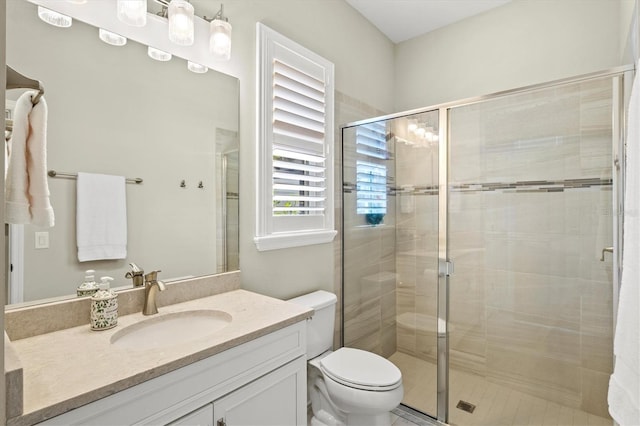 full bath featuring toilet, a shower stall, and vanity