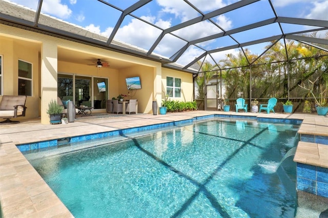 outdoor pool featuring glass enclosure, a patio area, and ceiling fan