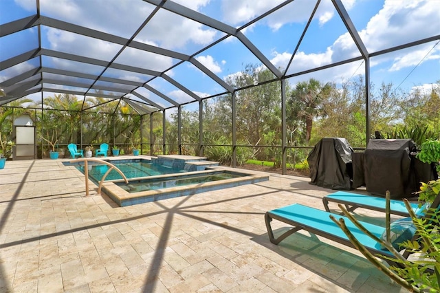 view of pool with a patio, a lanai, a pool with connected hot tub, and a grill