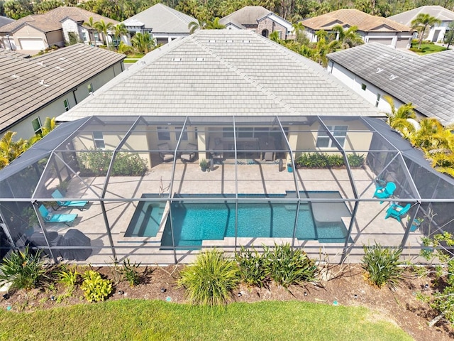 outdoor pool with a patio area, a lanai, and a residential view