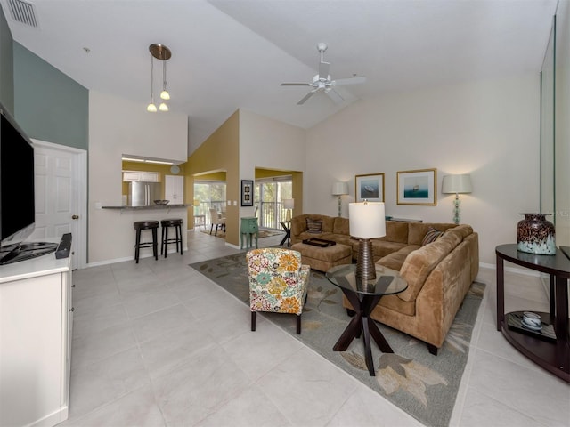 tiled living room with ceiling fan and high vaulted ceiling