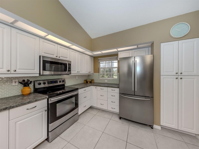 kitchen featuring appliances with stainless steel finishes, light tile patterned floors, white cabinets, and decorative backsplash