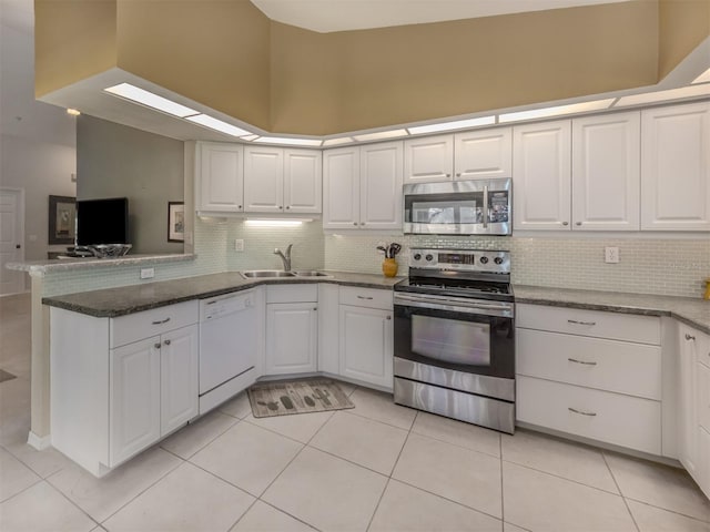 kitchen featuring white cabinetry, sink, kitchen peninsula, and appliances with stainless steel finishes