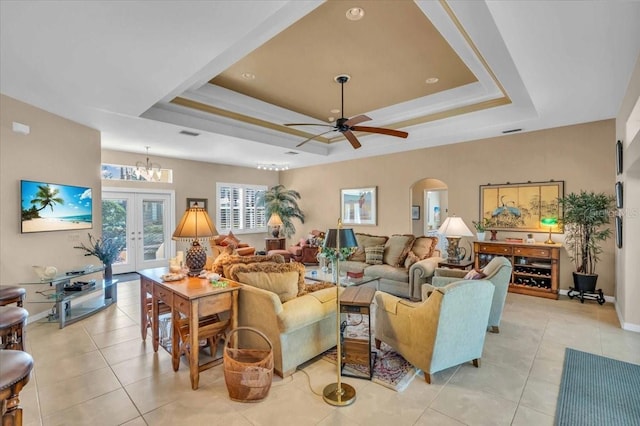 living room featuring french doors, light tile patterned flooring, and a tray ceiling