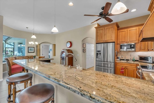 kitchen featuring tasteful backsplash, stainless steel appliances, sink, and hanging light fixtures