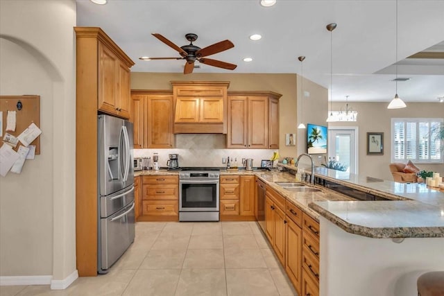 kitchen featuring appliances with stainless steel finishes, decorative light fixtures, tasteful backsplash, sink, and kitchen peninsula