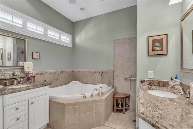 bathroom with vanity, tiled tub, tile patterned floors, and ceiling fan