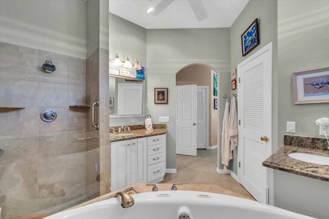 bathroom featuring tile patterned flooring, vanity, a bathing tub, and ceiling fan