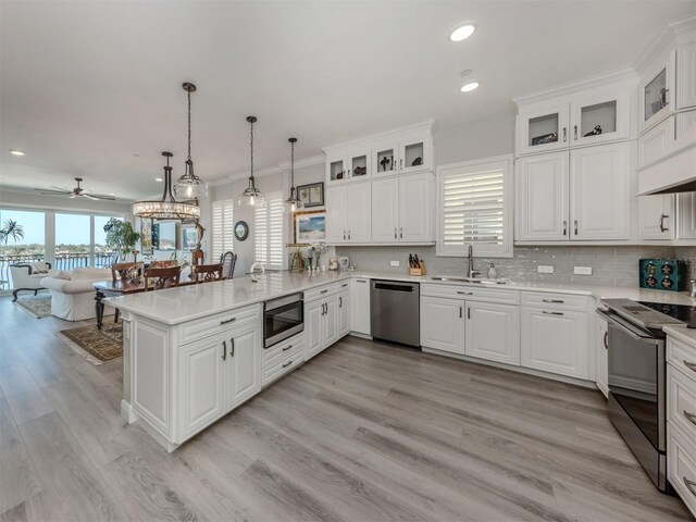 501 Tamiami Trl N Unit 502, Venice, FL 34285 - kitchen with a peninsula, a sink, stainless steel appliances, light countertops, and backsplash