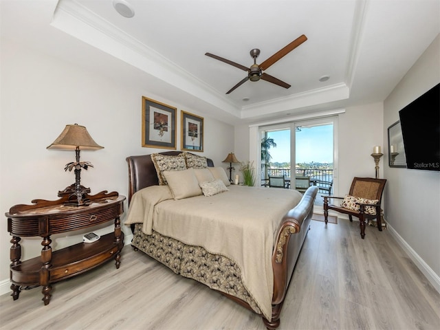 501 Tamiami Trl N Unit 502, Venice, FL 34285 - bedroom with light wood finished floors, baseboards, access to outside, a tray ceiling, and crown molding