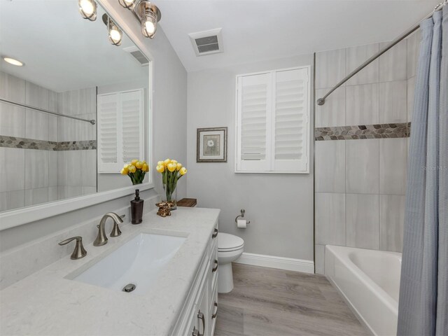 501 Tamiami Trl N Unit 502, Venice, FL 34285 - bathroom featuring toilet, wood finished floors, vanity, visible vents, and shower / tub combo with curtain