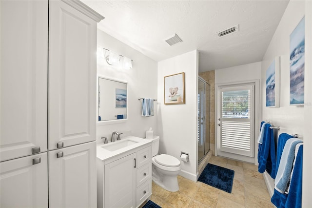 bathroom with a textured ceiling, toilet, vanity, and an enclosed shower