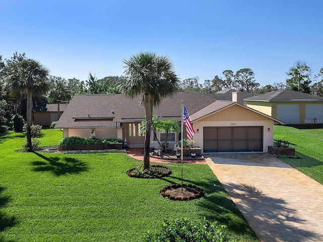 single story home featuring a garage and a front yard