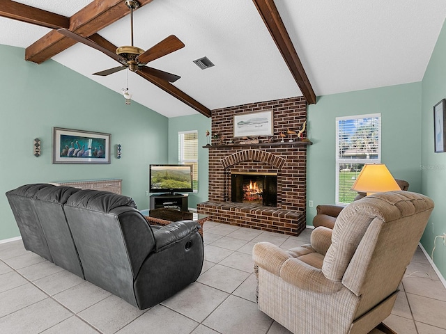 tiled living room with a brick fireplace, vaulted ceiling with beams, and ceiling fan