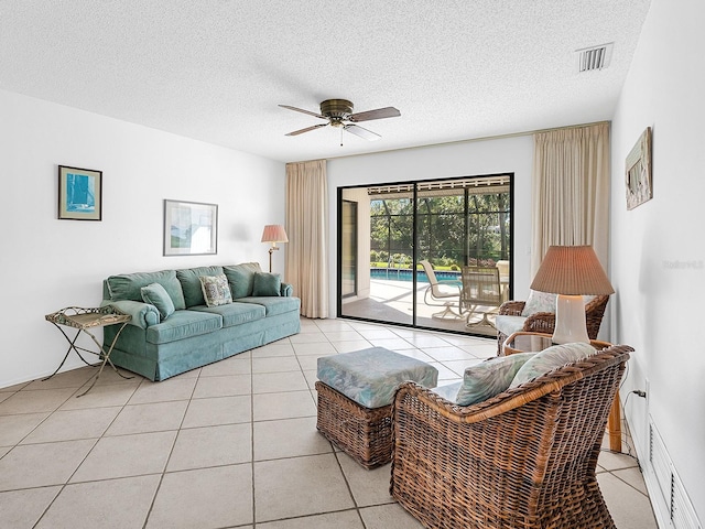 tiled living room featuring ceiling fan and a textured ceiling