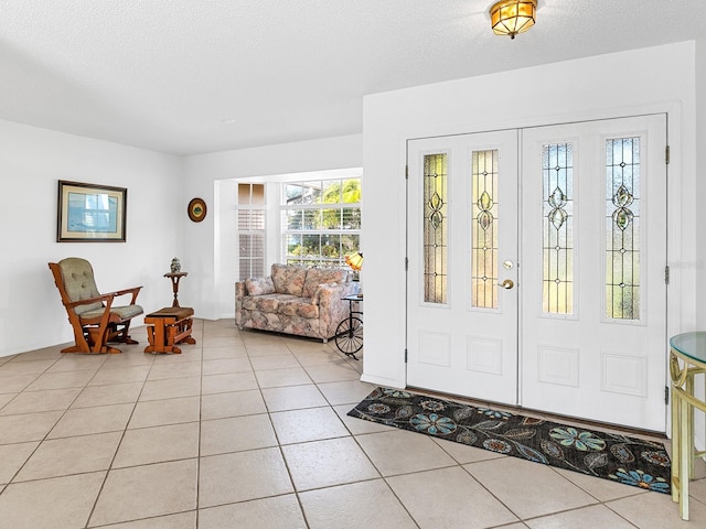 foyer entrance with light tile patterned floors and a textured ceiling