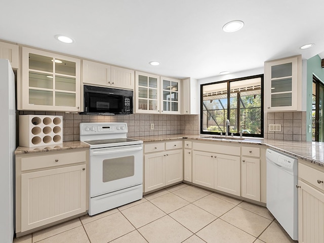 kitchen featuring sink, light stone counters, light tile patterned floors, white appliances, and backsplash