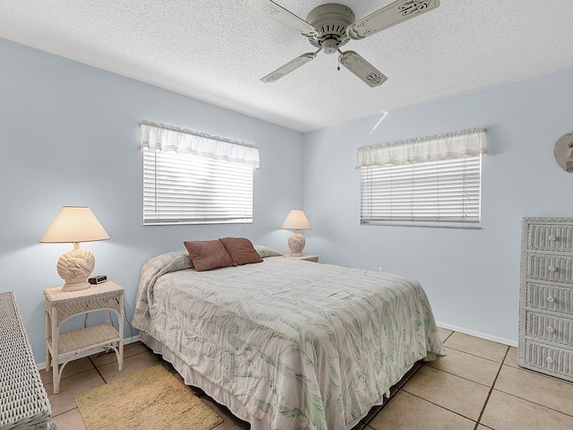 tiled bedroom with ceiling fan and a textured ceiling