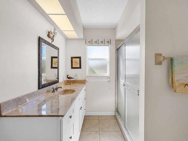 bathroom with vanity, toilet, a shower with door, tile patterned floors, and a textured ceiling