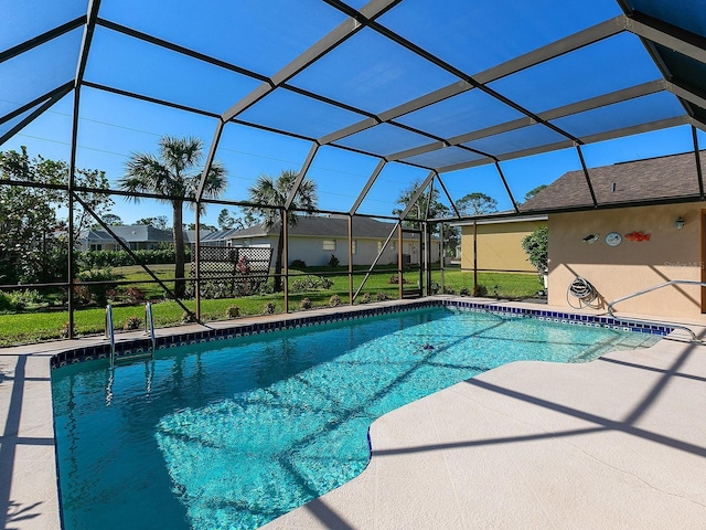 view of swimming pool featuring a lanai, a lawn, and a patio area