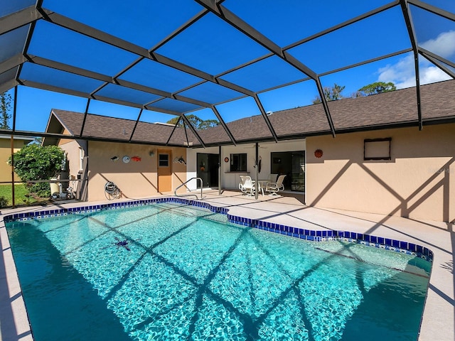 view of pool with glass enclosure and a patio area