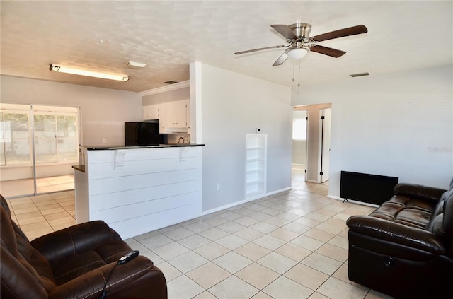 tiled living room featuring ceiling fan