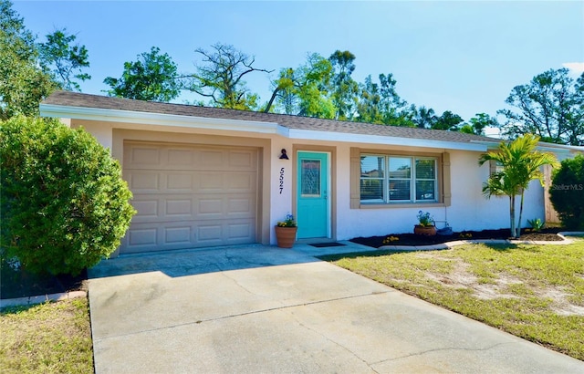 ranch-style home featuring a garage and a front lawn