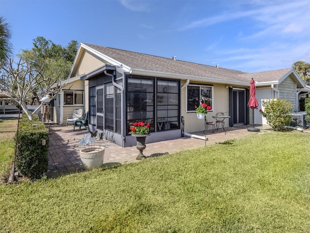 back of property featuring a sunroom, a lawn, and a patio area