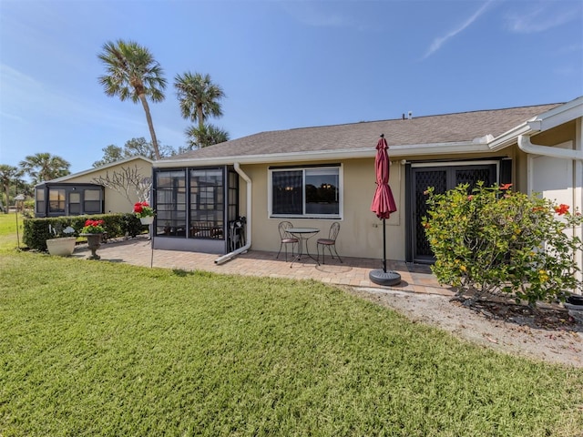 back of property with a sunroom, a yard, and a patio