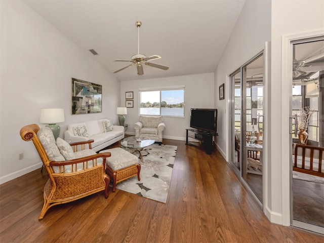 living room featuring dark wood-type flooring, ceiling fan, and vaulted ceiling