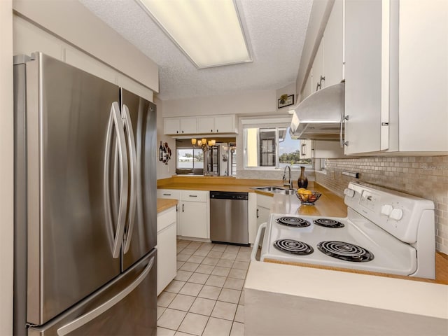 kitchen with sink, exhaust hood, white cabinets, and appliances with stainless steel finishes