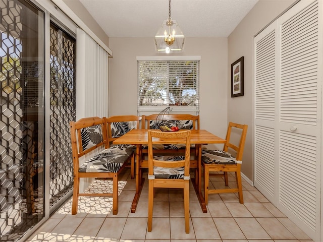 dining room featuring light tile patterned floors, a textured ceiling, and a chandelier