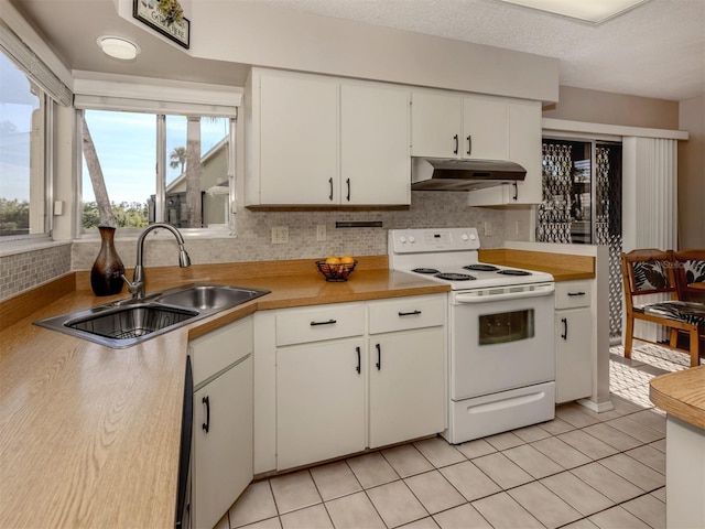 kitchen featuring sink, light tile patterned floors, white cabinets, and white range with electric cooktop